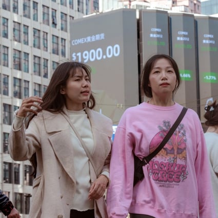 People walk near a large screen showing stock exchange data in Shanghai on March 15, a day after Asia-Pacific markets sank in the fallout from failed US banks. Photo: EPA-EFE