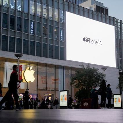 People walk near a display advertising Apple’s iPhone 14 outside its store in Shanghai on November 7, 2022. Photo: Reuters