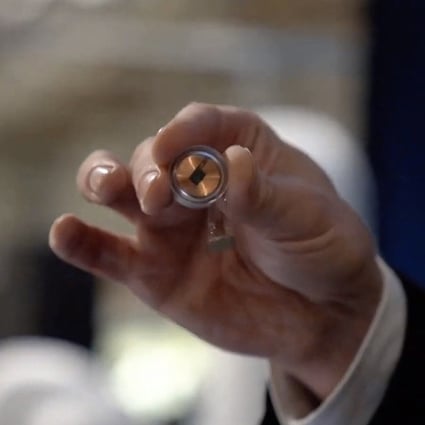 A Neuralink disk implant held by Elon Musk during a 2020 presentation. File photo: Neuralink via AFP