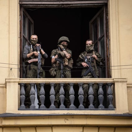 Members of the Wagner group stand on the balcony of the circus building in Rostov-on-Don, Russia, on June 24.  Yevgeny Prigozhin, commander of the mercenary group, had ordered his troops to march on Moscow but abruptly reached a deal with the Kremlin to go into exile and sounded the retreat on June 25. Photo: AFP