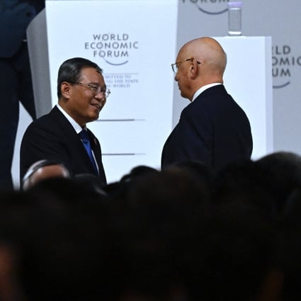 Chinese Premier Li Qiang talks with Klaus Schwab, founder and executive chairman of the World Economic Forum, after his speech during the opening ceremony. Photo: AFP