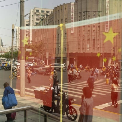 Chinese flags reflected in a window in Shanghai. Photo: Bloomberg