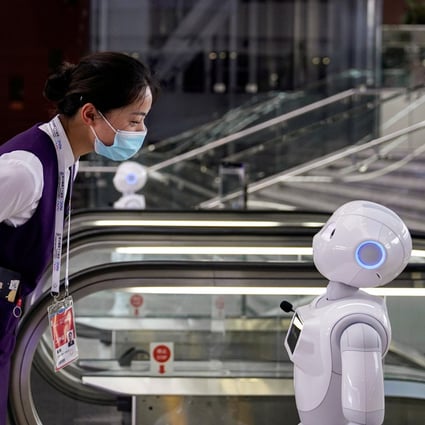 A staff member at the World Artificial Intelligence Conference looks at a robot at the venue in Shanghai on July 9, 2020. Photo: Reuters