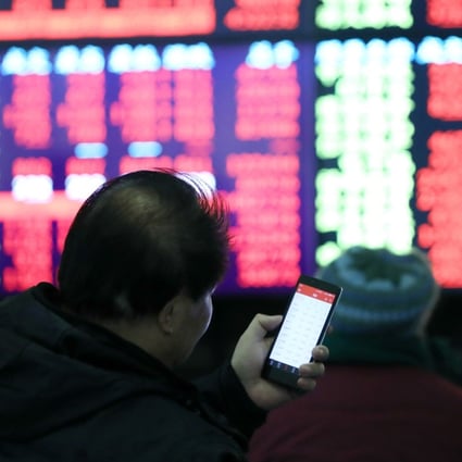 An investor checks his smartphone at trading hall in Shanghai on February 25, 2019. Photo: Xinhua