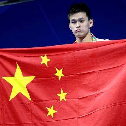 Sun Yang stands on the podium holding his national flag after receiving his gold medal in the men’s 400m freestyle final at the 18th Asian Games in Jakarta in 2018. Photo: AP