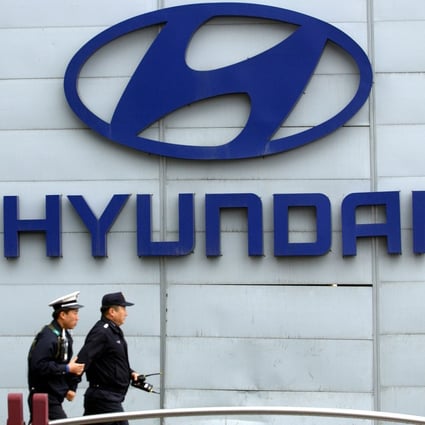 In this file photo taken on April 19, 2006, police officers walk past a Hyundai logo displayed in front of the Seoul headquarters pf South Korea’s largest carmaker. Photo: Jung Yeon-je/AFP