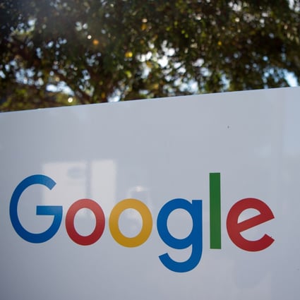 A man rides a bike past a Google sign and logo at the Googleplex in Menlo Park, California. Photo: AFP