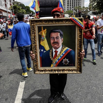 A painting depicting Venezuelan President Nicolas Maduro is displayed by a supporter during a pro-government demonstration in Caracas. Photo: AFP