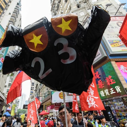 A protester holds up a hand-shaped prop adorned with the colours of the Chinese flag to protest about the possible enactment of Article 23 of the Basic Law at a rally in Hong Kong on October 1, 2018. NPC delegate Peter Wong’s support of national security legislation made him unpopular in some quarters. Photo: AFP