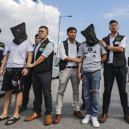 Guangdong police officers hand over three robbery suspects to their counterparts in Hong Kong last July. Photo: Edward Wong