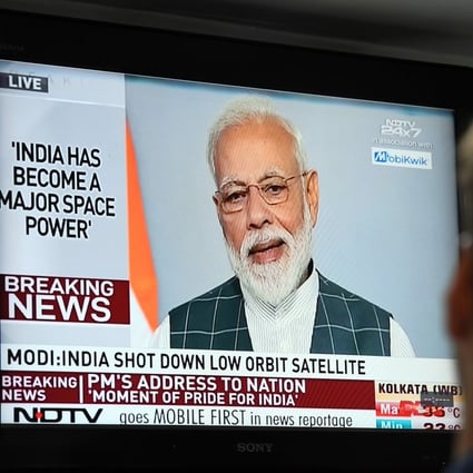 A man watches Indian Prime Minister Narendra Modi's address to the nation where he announced India had destroyed a low-orbiting satellite in a missile test. Photo: AFP