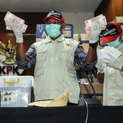 Officers from the corruption eradication commission with boxes of Indonesian currency totalling more than US$560,000. Photo: AFP