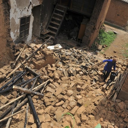 A woman walks on the debris of her collapsed house in the earthquake-hit Yao'an county, Yunnan province, on July 10, 2009. UBS said the earthquake prevented it from verifying the existence of China Forestry Holdings’ assets. Photo: Reuters/China Daily