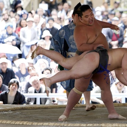 Sumo wrestlers perform a show fight during the annual “Honozumo” ceremonial sumo tournament in Tokyo on April 18, 2016. Photo: Reuters