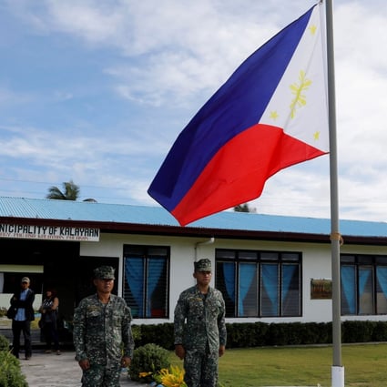 Filipino soldiers stand at attention on Thitu Island in the South China Sea. Photo: Reuters