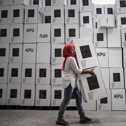 An Indonesian election commission worker arranging ballot boxes in Surabaya. Photo: AFP