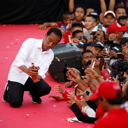 Indonesia's President Joko Widodo takes pictures with supporters during a campaign rally, on March 24. Photo: Reuters