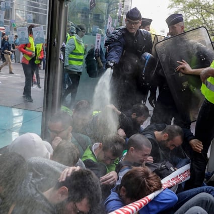 French police use pepper spray at close range on climate change activists blocking the entrance of the Societe Generale bank headquarters near Paris, during an Extinction Rebellion demonstration on April 19. Photo: AFP
