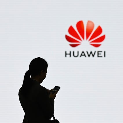 A staff member of Huawei uses her mobile phone at the Huawei Digital Transformation Showcase in Shenzhen. Photo: AFP