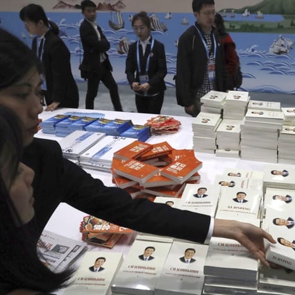 Attendees pick up copies of a book on President Xi Jinping’s governance at the forum’s media centre in Beijing on Friday. Photo: AP
