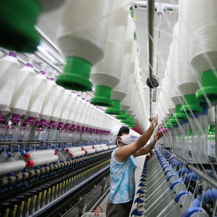 A worker operates machines for making yarn at a textile factory in Huaibei, east China's Anhui province. Photo: AFP