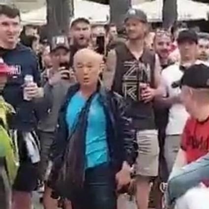 An elderly Asian man looks on in shock after being pushed into a fountain at a Barcelona square by a Liverpool fan. Photo: Twitter