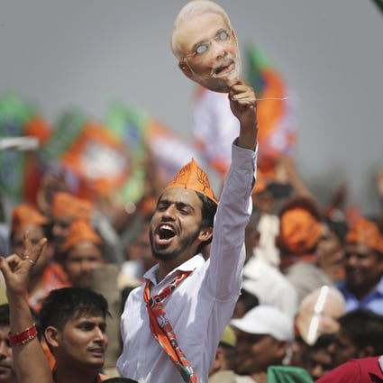 A BJP supporter shouts slogans as he holds up a mask of Indian Prime Minister Narendra Modi during an election rally in Meerut, India, on March 29. Photo: AP