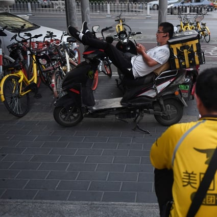Meituan delivery riders wait for food delivery assignments in Beijing on June 26, 2018. Photo: AFP