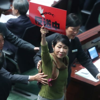 Lawmaker Claudia Mo is escorted from the Legislative Council chamber after accusing Chief Executive Carrie Lam of lying. Photo: Sam Tsang