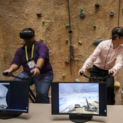 Attendees wear HTC Corp. Vive VR headsets while riding the VirZOOM Inc. bike gaming controller during the vSports Competition at the 2017 Consumer Electronics Show (CES) in Las Vegas, US. Photo: Bloomberg