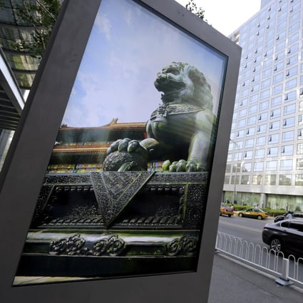 FILE PHOTO: An advertising board (L) showing a Chinese stone lion is pictured near an entrance to the headquarters (R) of China Securities Regulatory Commission (CSRC), in Beijing, China, September 7, 2015. Photo: REUTERS