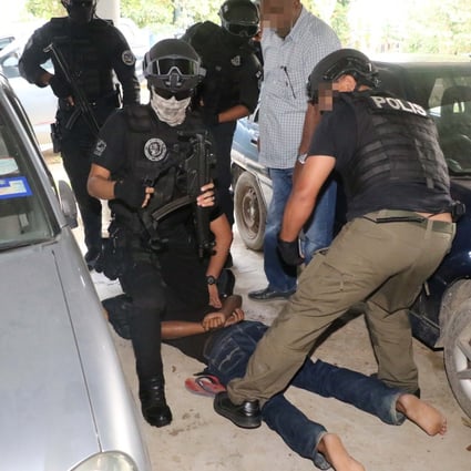 Malaysian anti-terror police handle one of the suspects during a sting operation last week. Photo: Handout