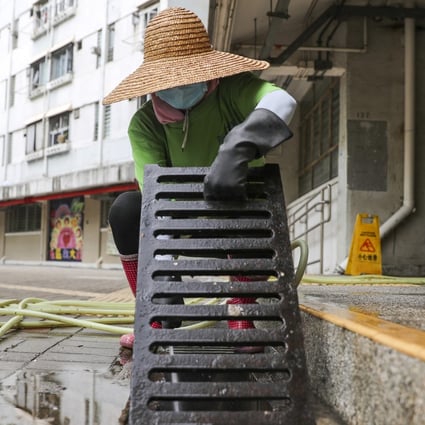 A cleaner tackles the drains at Tuen Mun’s Yau Oi Estate. Photo: Sam Tsang