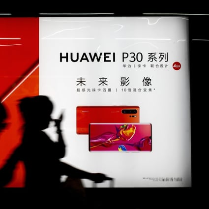 Commuters pass a Huawei P30 smartphone advertisement inside a Beijing subway station. Photo: AP