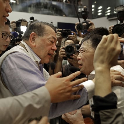 Pro-democracy lawmaker Wu Chi-wai (centre, right) talks to pro-Beijing lawmaker Abraham Razack at a meeting last Saturday that descended into chaos at the Legislative Council. Photo: AP