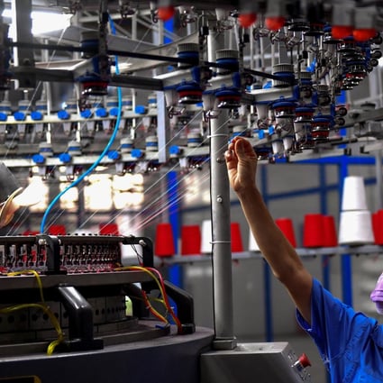 An employee monitoring a circular weaving machine at a textile factory in Shangqiu in China's central Henan province. Photo: Agence France-Presse