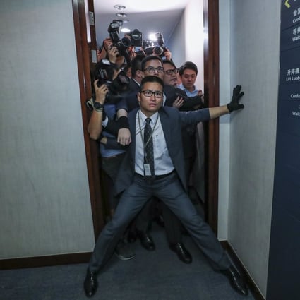 A security officer tries to stop reporters from entering the bills committee meeting. Photo: Sam Tsang