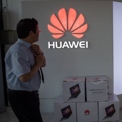 A man walks next to a Huawei logo in a shopping centre in Beijing on Monday. Photo: EPA-EFE