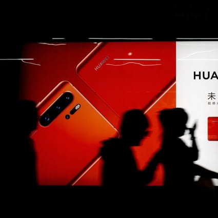 Commuters walk by an advert for the the new Huawei P30 smartphone inside a subway station in Beijing Monday, May 13, 2019. Photo: AP