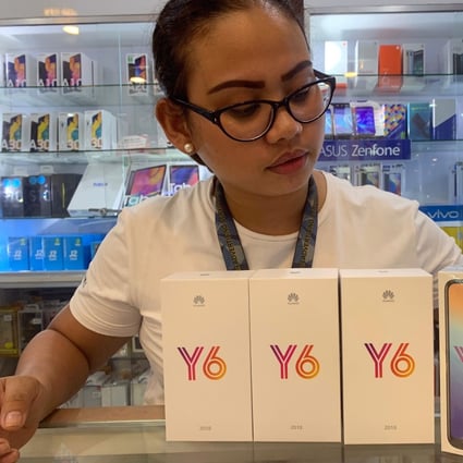 Rizal Anotado, the manager of a phone reselling shop in the southern Philippine city of Koronadal, displays her Huawei Y6 devices. Photo: Jef Maitem