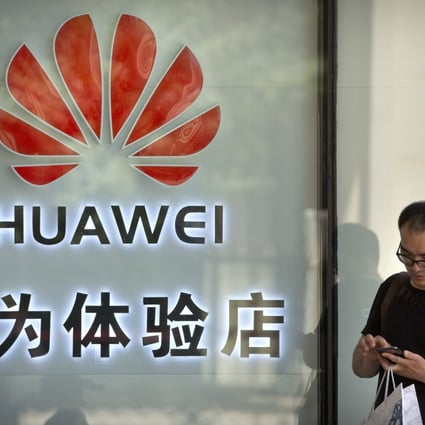 A man uses his smartphone outside a shop selling Huawei products in Beijing on Wednesday. The Chinese tech giant has filed a motion in the US courts challenging the constitutionality of a law that limits its sales of telecoms equipment. Photo: AP