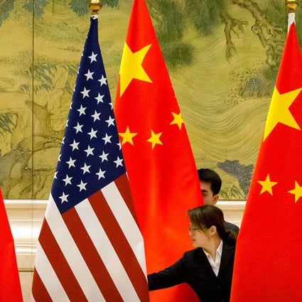 Staff adjust US and Chinese flags before the opening session of trade negotiations between US and Chinese trade representatives in Beijing in February. Photo: Reuters