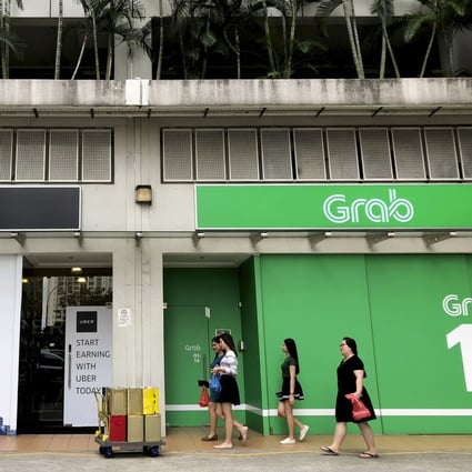 People walk past the offices of ride-hailing apps in Singapore. A start-up from the city state hopes to launch the same technology in West African nations. Photo: AP