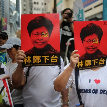 Protesters cover their faces with posters of Chief Executive Carrie Lam during the march from Causeway Bay to the government headquarters in Admiralty. Photo: Winson Wong