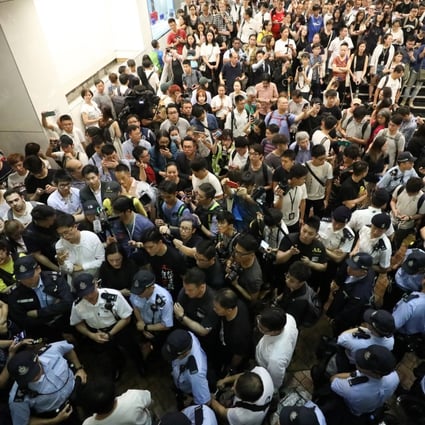 Residents and legislators surround police at an MTR station to question why they are stopping and searching people on Tuesday night. Photo: Dickson Lee