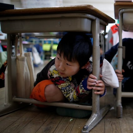 Tokyo schoolchildren take shelter under desks during an earthquake simulation exercise. Photo: Reuters