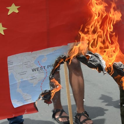 Activists burn a mock Chinese flag with a map of the South China Sea during a protest in front of the Chinese consulate in Manila. Photo: AFP