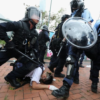 Police in full riot gear restrain a protester outside Legco on Wednesday. Photo: Felix Wong