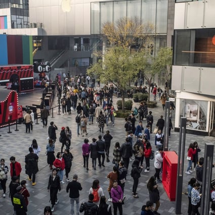 Shoppers and pedestrians walk past stores in the Sanlitun area of Beijing. Retail sales, a key indicator of consumer demand in China, grew by 8.6 per cent, up from April’s reading of 7.2 per cent, which was the lowest rate of growth since May 2003. Photo: Bloomberg