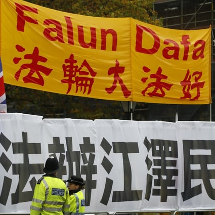 Two police officers stand guard in front of Falun Gong supporters as they protest outside Downing Street ahead of the arrival of Chinese President Xi Jinping in London in October 2015. Photo: AP